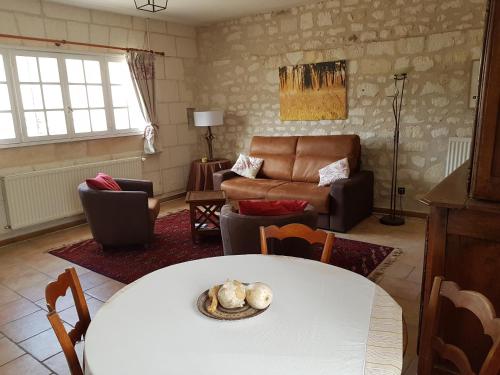 a living room with a table and a couch at La Chancellerie in Huismes