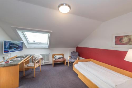a small room with a bed and a desk and a desk at Landgasthof Ochsen in Sinzheim