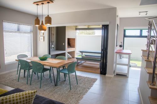 ein Esszimmer und ein Wohnzimmer mit Tisch und Stühlen in der Unterkunft Turmalin Cottage Unit 1 in Swakopmund
