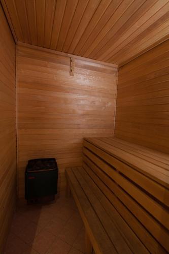a small wooden sauna with a trash can in it at Liivakell Holiday Homes in Narva-Jõesuu