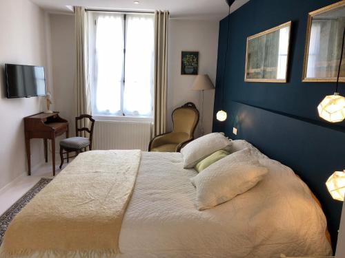 a bedroom with a large bed with a blue wall at Villa Mary in Amboise