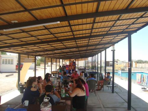 um grupo de pessoas sentadas em mesas sob um pavilhão em Cabañas Ecodesert em La Tirana
