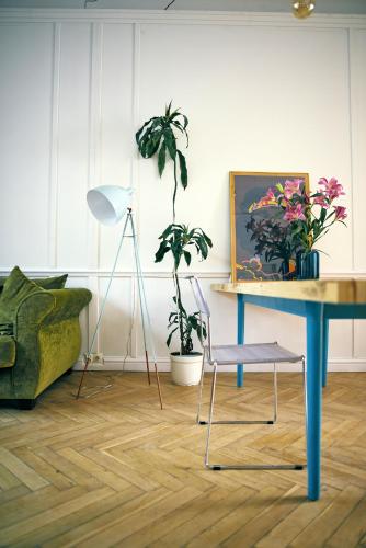 ein Wohnzimmer mit einem blauen Tisch und Pflanzen in der Unterkunft 4th Floor Bed and Breakfast in Warschau