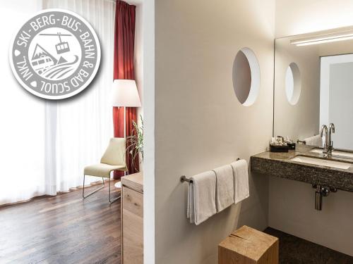 a bathroom with a sink and a mirror at Hotel Belvedere Scuol in Scuol