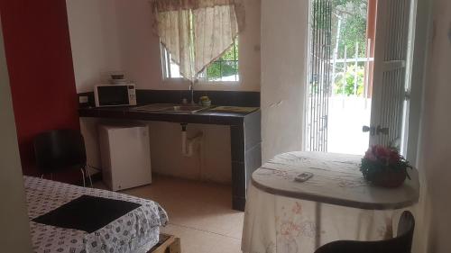 Habitación pequeña con lavabo y mesa con cama en Posada Nativa Trinsan Centro, en San Andrés