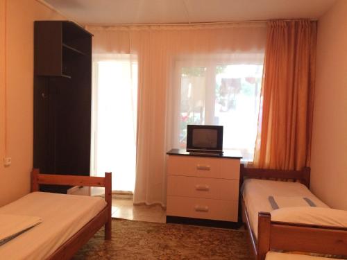 ヴィチャゼヴォにあるTatiana Guest Houseのベッドルーム1室(ベッド2台、ドレッサー内のテレビ付)