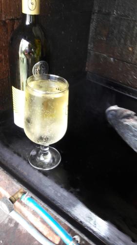 a drink sitting on a table with a bottle of wine at Željko Apartmani in Lopar