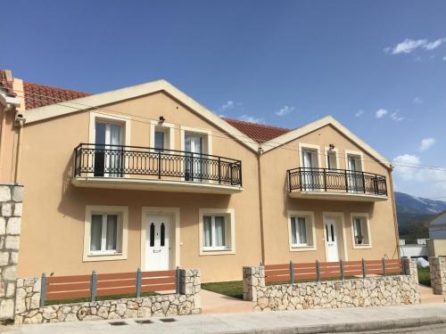 a house with two balconies on top of it at Helianthus Apartments in Argostoli