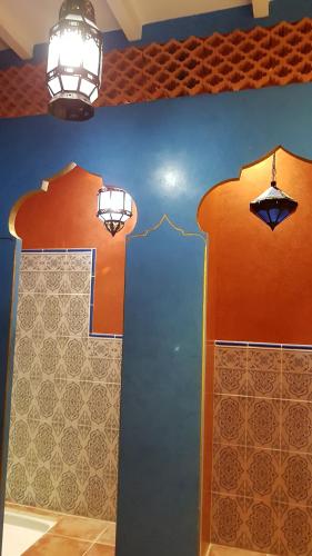 Cette chambre est dotée d'un mur orange et bleu. dans l'établissement La Lucques Masabelle, à Mirepeisset