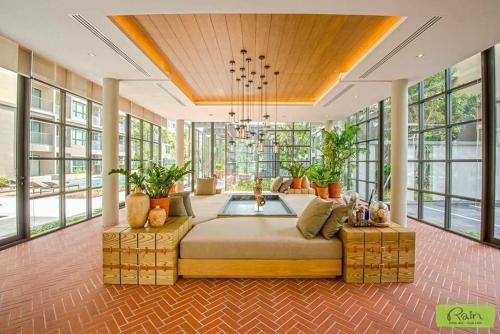 a large bedroom with a large bed in a room with windows at rain condo Cha-am 2 bedroom by Napa in Cha Am