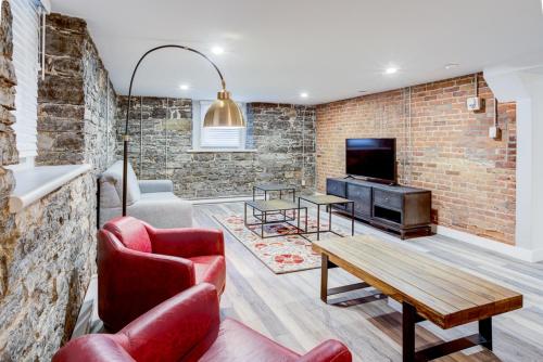 een woonkamer met een bakstenen muur bij L'Adresse sur Grande-Allée Lofts in Québec