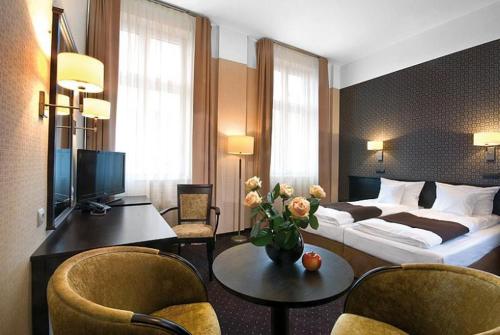 Habitación de hotel con cama, mesa y sillas en Hotel Senator, en Zbąszyń