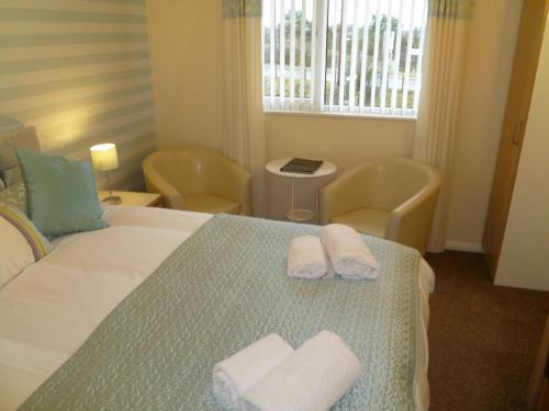 a bedroom with a bed with two towels on it at Greenlaw Guest House in Gretna Green
