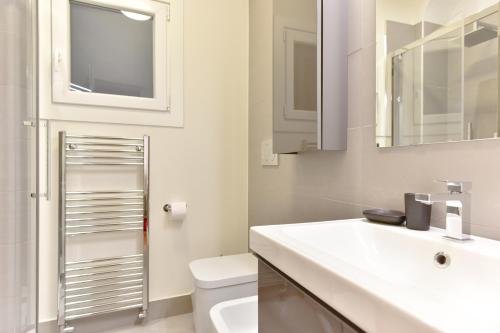 uma casa de banho com um lavatório, um WC e um espelho. em iFlat Via Veneto Design Studio em Roma