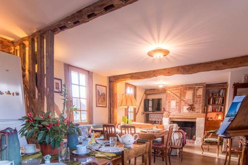 un salon avec une table et une salle à manger dans l'établissement B&B - Le Clos aux Masques, à Saint-Pierre-Azif