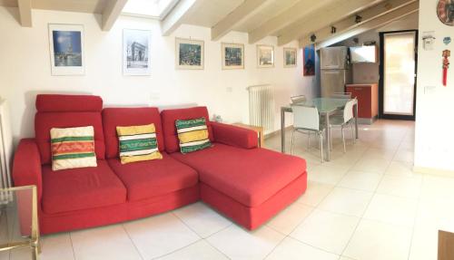 a red couch in a living room with a table at Attico with swimming pool in Lenno