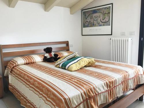 um urso de peluche deitado em cima de uma cama em Attico with swimming pool em Lenno