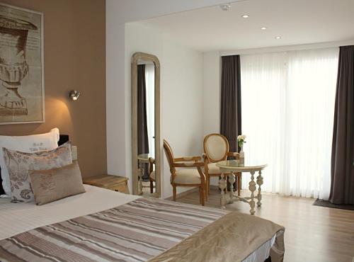 a bedroom with a bed and a table and a chair at B&B Villa Verde in De Haan