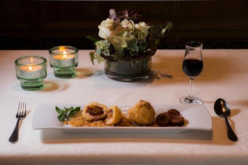 a plate of food on a table with a glass of wine at Hotel Zum Pinzger in Stumm