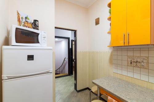a kitchen with a microwave on top of a refrigerator at Lux Apart Lviv apartments in Lviv