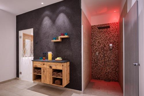a bathroom with a shower with a wooden vanity and a wall at Hotel Garnì Savoy in Castelrotto