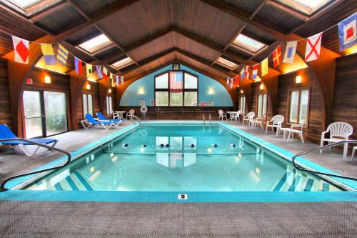 - une grande piscine dans une pièce avec des chaises et des tables dans l'établissement Cape Cod Holiday Estates, a VRI resort, à Mashpee