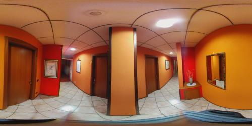 ポルト・マントヴァーノにあるHotel Bed and Breakfast Il Granaio Mantovaのオレンジ色の壁とオレンジ色のドア、タイルフロアの廊下
