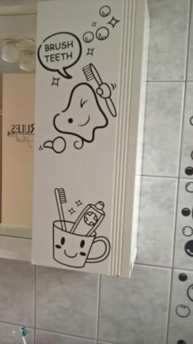 a bathroom with a wall with some drawings on it at Apartment & Rooms Marigold in Baška Voda