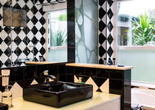 a bathroom with a sink and black and white tiles at Quinta da Mafalda in Mira