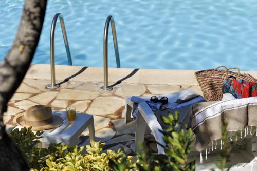 una mesa con un sombrero sentada junto a una piscina en U Cantu di i Cardellini, en Porto Vecchio