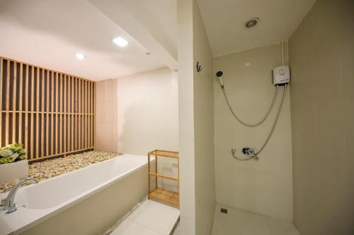 a bathroom with a bath tub and a shower at Siam Nitra Boutique Hotel in Bangkok