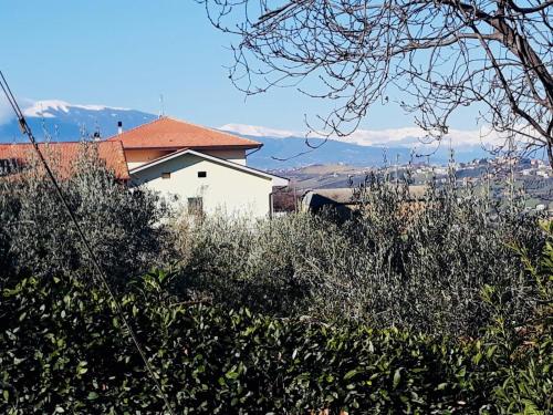 a white house with mountains in the background at Ellebì B&B in Montone
