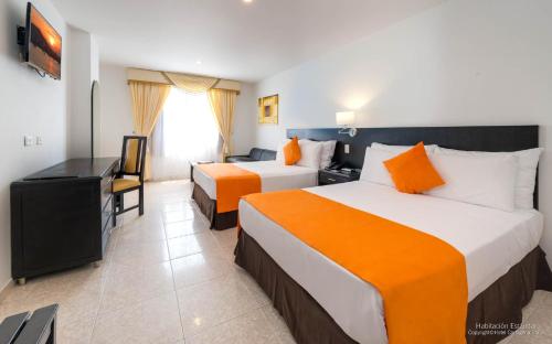 a hotel room with two beds and a television at Hotel Cartagena Plaza in Cartagena de Indias