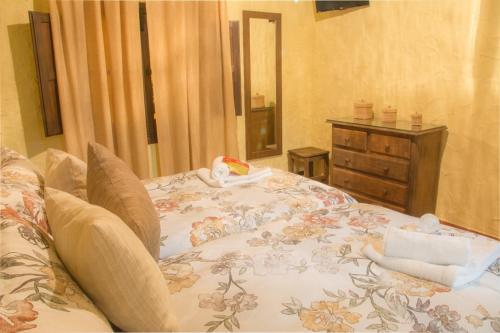 a bedroom with a bed with a flowered blanket at Casa Mirador San Pedro in Arcos de la Frontera