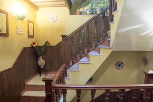 a winding staircase in a home with wooden railings at Casa Mirador San Pedro in Arcos de la Frontera