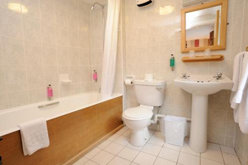 佩特戴爾的住宿－派特戴爾酒店，浴室配有卫生间、盥洗盆和浴缸。