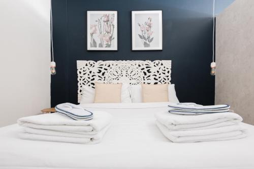 ロンドンにあるThe Paddington Studio - Cool & Stylish 1BDR Mewsのベッドルーム1室(白いベッド1台、タオル付)
