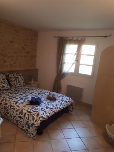a bedroom with a bed with two teddy bears on it at Mas de la Frigoule in Le Pouget