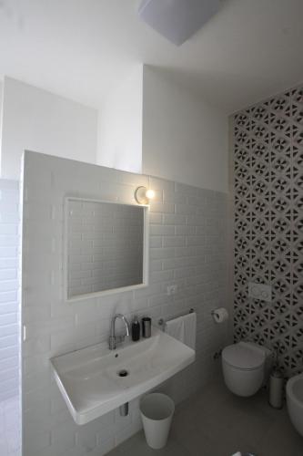 a white bathroom with a sink and a toilet at Il Capitano in Lerici