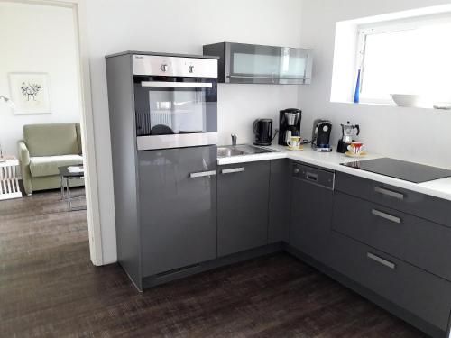 una cocina con fregadero y estufa horno superior en Stadtoase Koblenz, en Coblenza