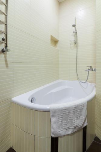 a white bath tub in a bathroom with a shower at Lux Apart Lviv apartments in Lviv