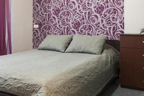 a bedroom with a bed with a purple and white wall at Lux Apart Lviv apartments in Lviv