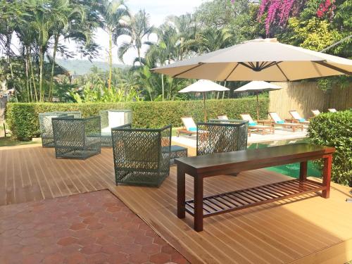 a patio with a table and chairs and an umbrella at The Apsara Rive Droite in Luang Prabang