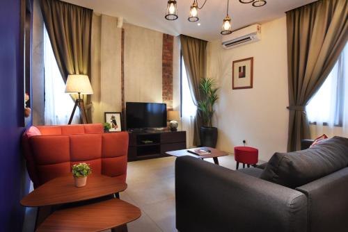 uma sala de estar com um sofá e uma televisão em Backyard Rio Melaka em Malaca