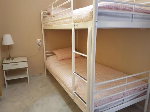 セビリアにあるTRIANA RUISEÑORのベッドルーム1室(二段ベッド2組、テーブル付)