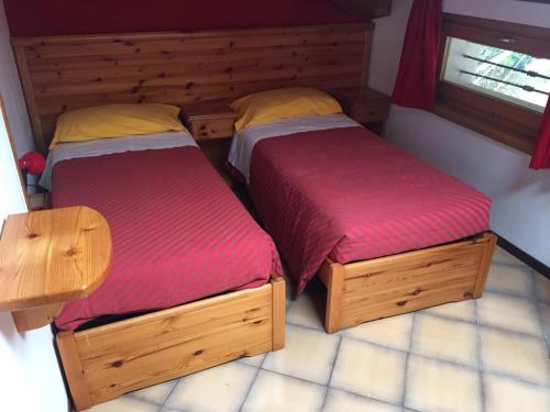 two twin beds in a room with sidx sidx sidx sidx at Hotel Carrara in Serina