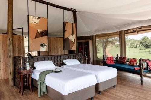 two beds in a room with a tent at Saruni Leopard Hill in Naboisho