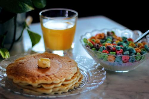 a table with a plate of pancakes and a bowl of fruit at Crates at the Gaythering - Men Only in Miami Beach