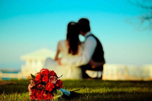 a bride and groom kissing next to a bouquet of flowers at Hotel Villa Serena in Las Galeras