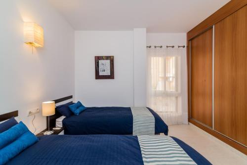 1 dormitorio con 2 camas y ventana en El Higuerón Stunning two BDR Apt., en Fuengirola